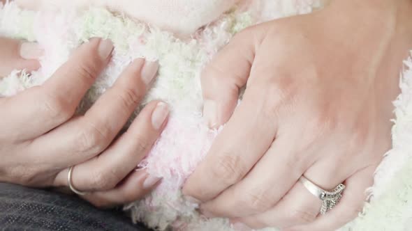 Slow motion. Mother holding her infant daughter in pink and white stripes outfit. alt