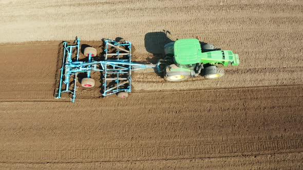 Tractor with Disc Harrows on the Farmland alt