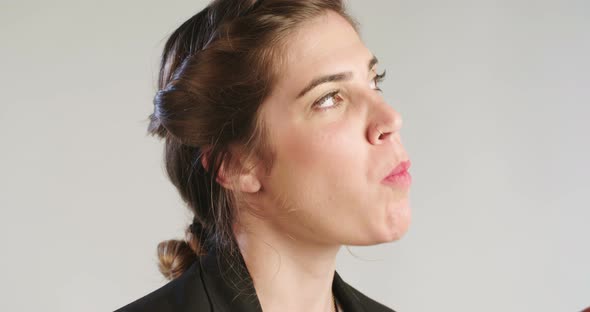 close up of a woman eating an apple on a white studio background alt
