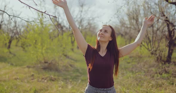 Happy Brunette Girl Walks Through the Forest and Enjoys the Weather