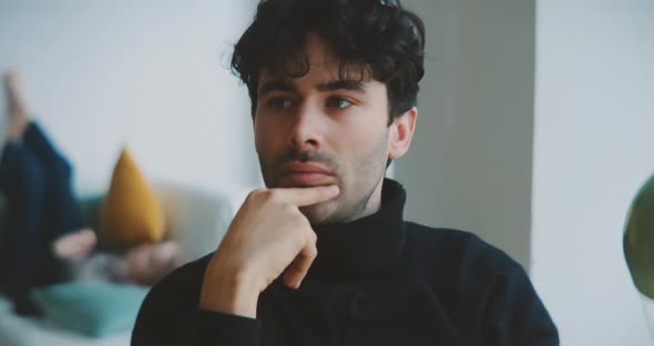 Young man thinking while sitting at table alt