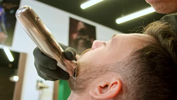 Barbershop Customer Lies and Enjoys Stylist Trimming Beard alt