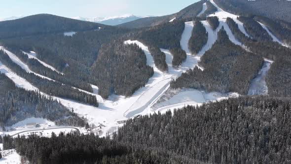 Aerial Ski Slopes with Skiers and Ski Lifts on Ski Resort. Snowy Mountain Forest alt