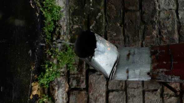 Vertical Shot of a Stainless Steel Rain Pipe Against a Brick Wall alt