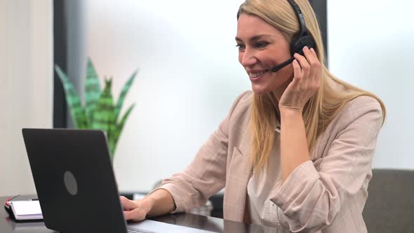 Happy Businesswoman Wearing Wireless Headset Sitting at Home Office