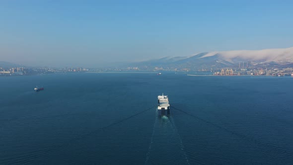 Aerial Top Down View of Ultra Large Cargo Ship at Sea Leaves Port at Sunny Day alt