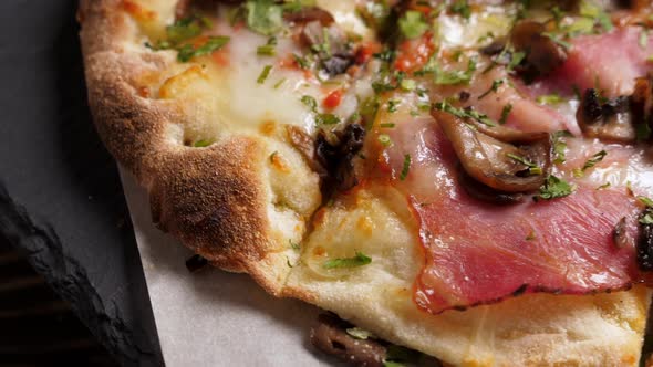 One Salami and Bacon Pizza on Black Slate Platter Rotating alt