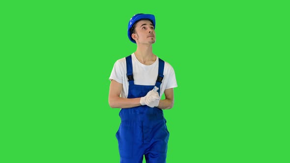 Confident Young Male Builder Walking Looking to the Sides on a Green Screen Chroma Key