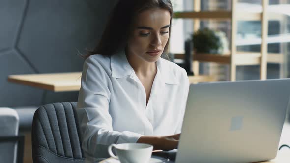 Beautiful Woman Working in Cafe on Her Laptop with Camera Movement alt