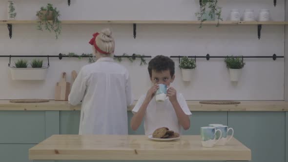 Beautiful Mother Pulls Out Freshly Baked Cookies From the Oven and Serves Her Little Son