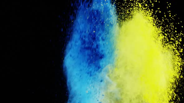 Blue and yellow dust powder blowing against black background alt