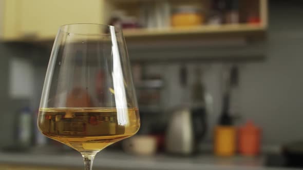 White wine is Poured into Transparent Glass The camera Moves Around the Table in the kitchen alt