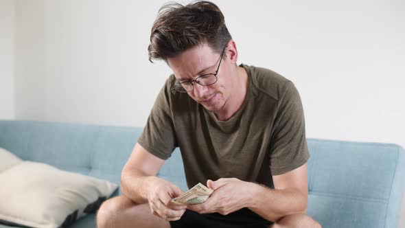 Men's Hands Count Cash Dollars and Other Currencies at Home in a Bright Room alt