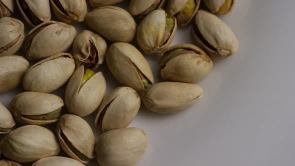 Cinematic, rotating shot of pistachios on a white surface - PISTACHIOS 005 alt