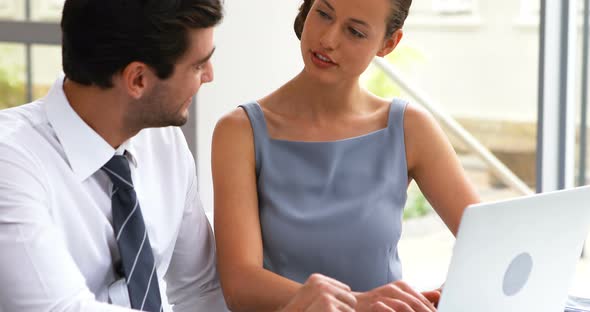 Business executives discussing over laptop 4k alt