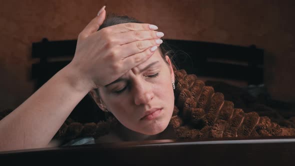 Young Girl Feels Unwell Lying on a Bed Under a Blanket Closeup alt