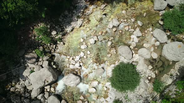 Aerial view of a person passing through the Soca River on a zip line in Slovenia alt
