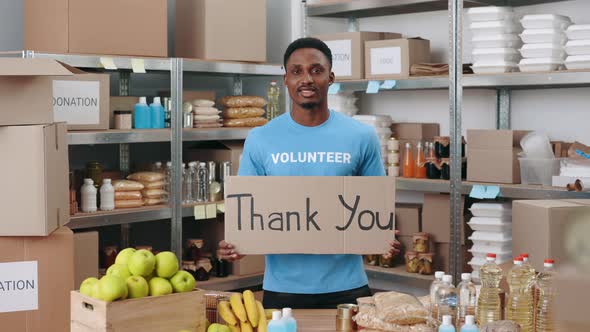 Young Male Volunteer Holding Banner with Phrase Thank you alt