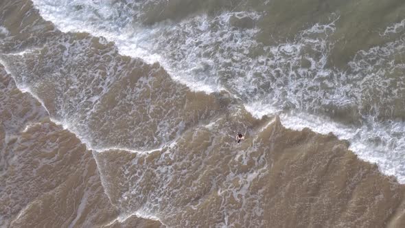 Drone Rotating Around Person Swimming in Ocean
