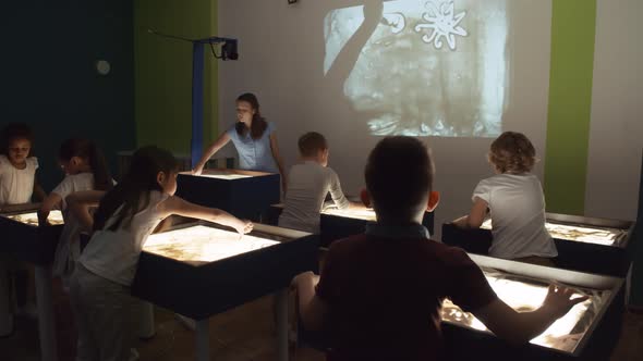 Woman Teaching Sand Animation Class for Children alt