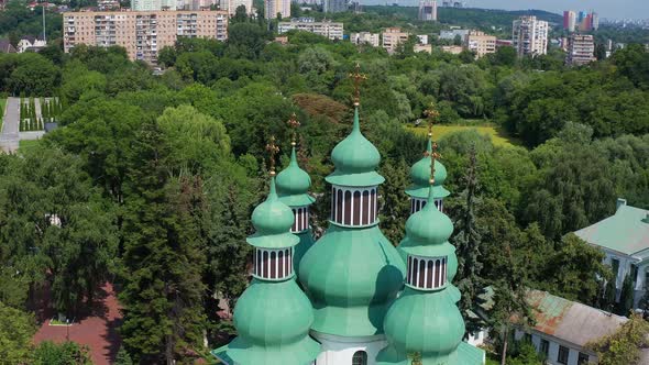 Nice top view of the church. Green domes among the trees. Monastery in the forest. alt