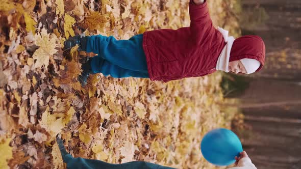 Vertical Clip  Small Child is Playing with His Mother in Inflatable Balloons alt