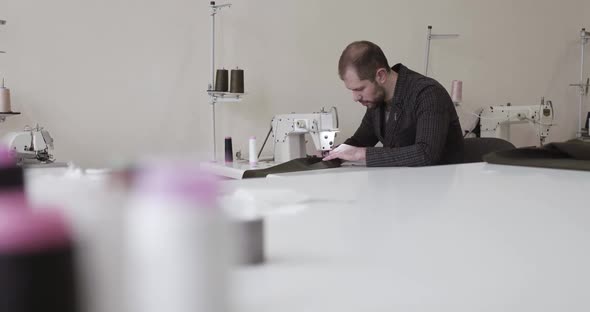 The Tailor Using the Sewing Machine to Sew a Clothes in Atelier alt