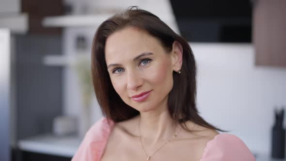 Attractive Caucasian Brunette Woman Looking at Camera Smiling Standing in Kitchen at Home alt