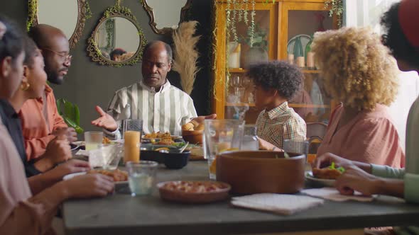 African American Family Praying before Dinner at Home alt
