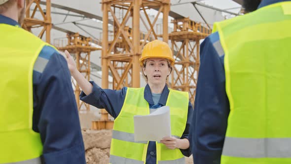 Construction Supervisor Giving Instructions to Workers alt