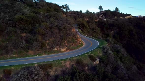 Tight Curve of Mountain Road beside Steep Cliff at Dawn, Drone Orbit alt