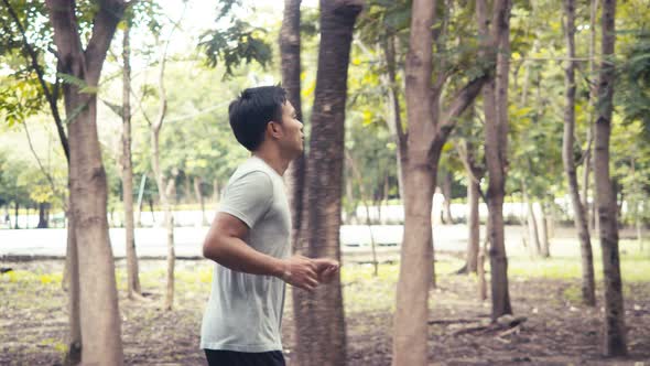 Authentic handsome Asian man running in the public park.