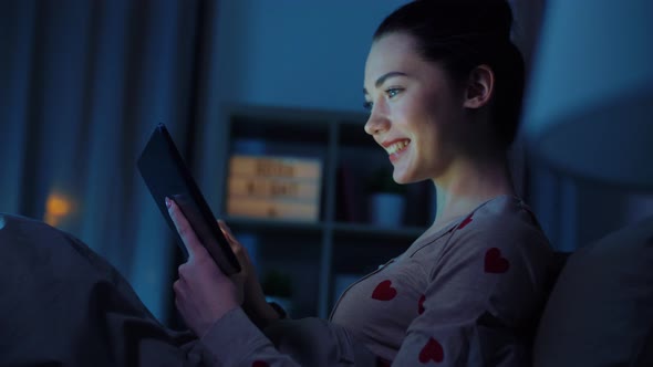 Teenage Girl with Tablet Pc in Bed at Night