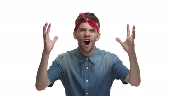 Handsome Caucasian Male Model with Red Bandana Shouting No and Holding Hands on Head Looking