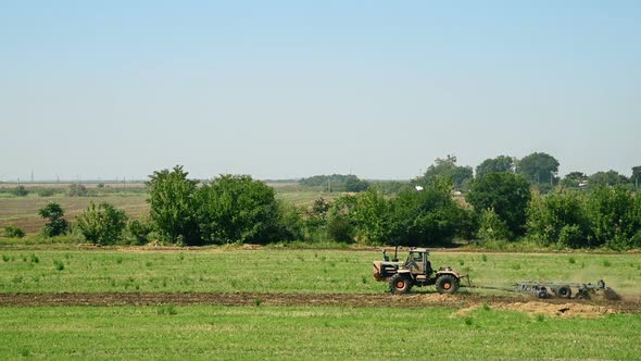 Tractor Plows On Green Field