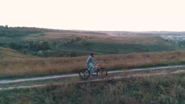 Guy Rides a Bicycle on a Background of Nature