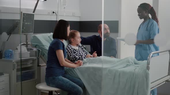 African American Pediatric Asisstant Monitoring Sick Child Discussing Recovery Treatment alt