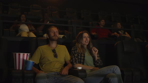 Beautiful Girl Looking Scary While Watching Film and Snuggling to Her Boyfriend Sitting Next to Her alt