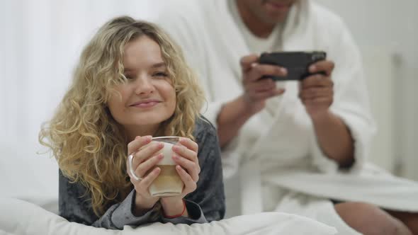 Portrait of Happy Charming Young Woman Smelling Morning Cappuccino Smiling As Unrecognizable Man alt