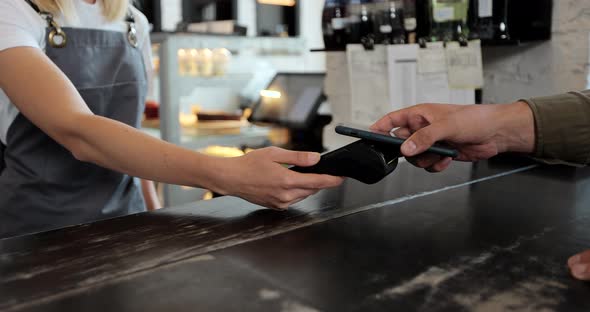 Close Up Male Customer Pays for Take Away Coffee with Contactless Nfc Payment Technology on alt