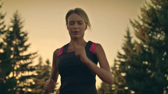 Sport Woman Running in Park at Sunset. Tired Runner Stop for Break at Park Road alt