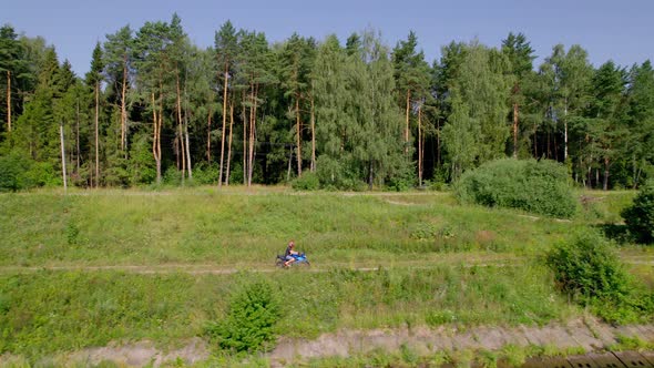 A Young Man Rides a Motorcycle Outside the City