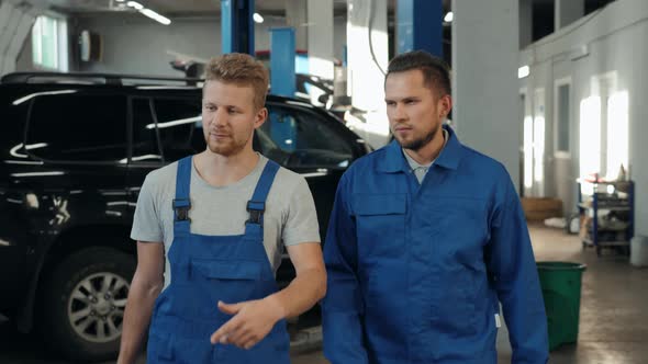 Factory Worker in a Hard Hat is Walking Through Industrial Facilities Service Workshop Factory Car alt