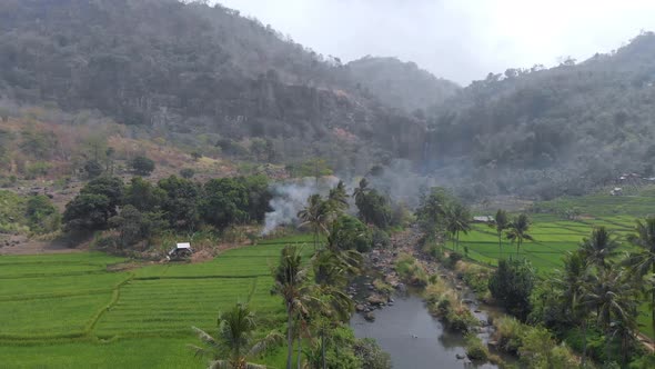 Beautiful aerial view of hills with rice field terrace and waterfall