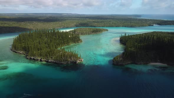 Amazing aerial parallax view of the Isle of Pines and Oro's Bay as the forest stretches to the horiz alt