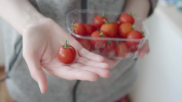 A Small Cherry Tomato in a Woman's Hand