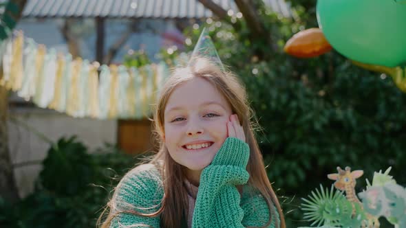 Birthday Girl Looks at Camera Sitting at the Backyard Party on a Sunny Day alt