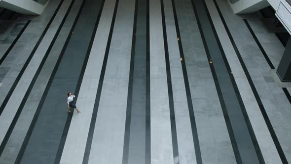 Top view. Executive businesswoman walks through empty lobby business center alt