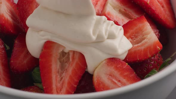 White chocolate pouring over fresh strawberries