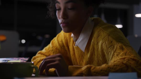 Tired businesswoman working on laptop in a modern office alt